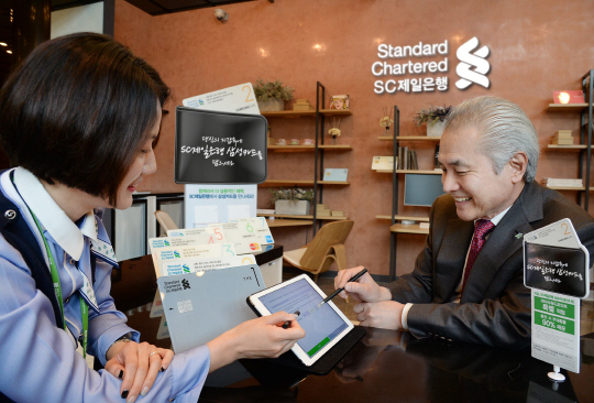 지난 11일 박종복 SC제일은행장(오른쪽)이 서울 종로구 SC제일은행 본점에서 모빌리티플랫폼을 이용해 SC제일은행 삼성카드 발급신청을 하고 있다.  SC제일은행 제공